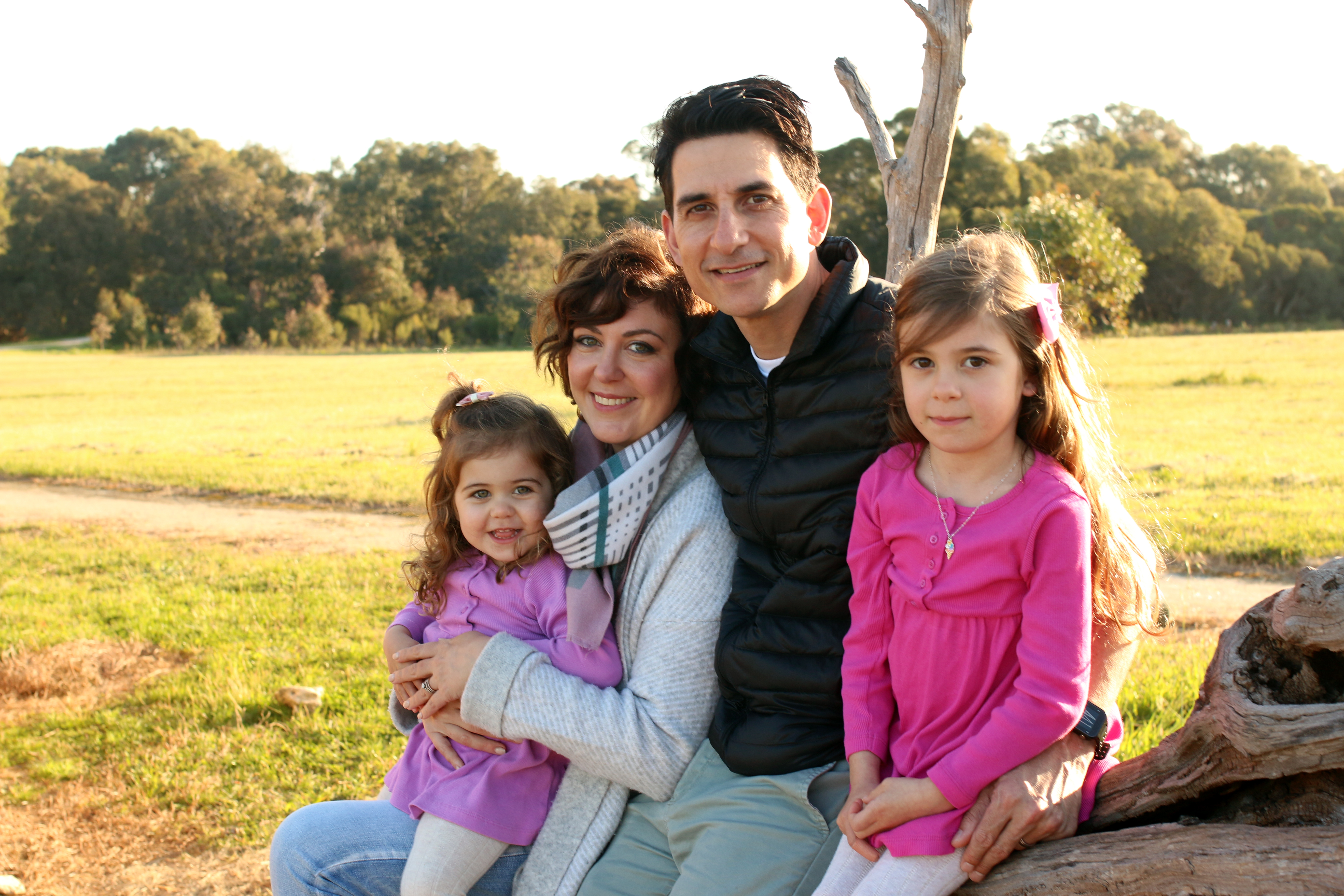 Woman Paola Magni man and two children sat in park