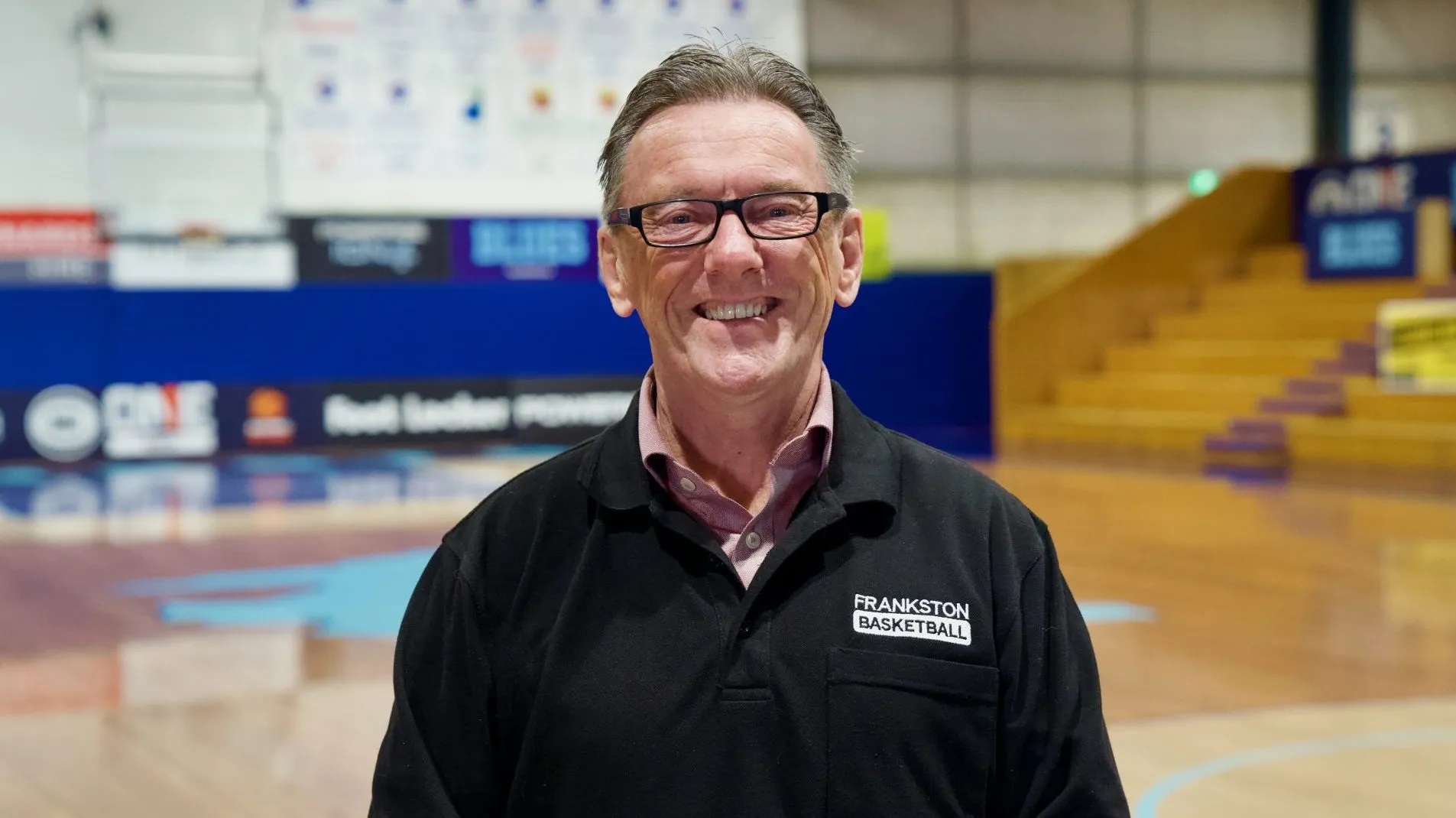 Wayne Holdsworth, the founder of charity SmackTalk, standing on a basketball court