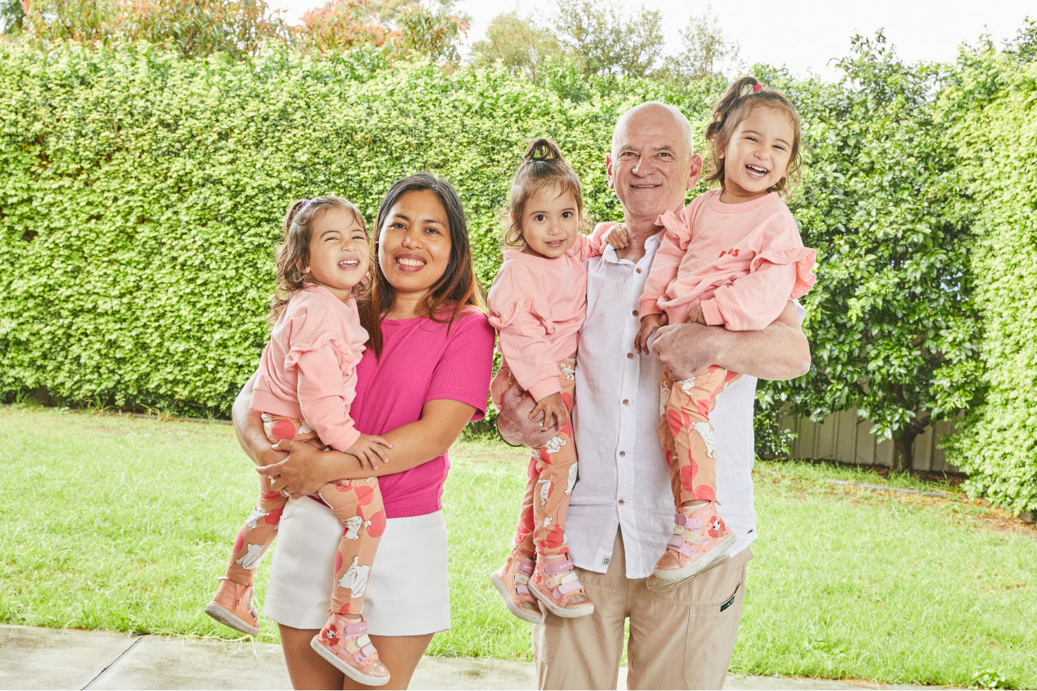 Image of mum and dad holding identical triplet girls